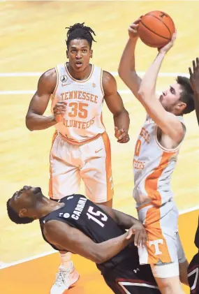  ?? BRIANNA PACIORKA/NEWS SENTINEL ?? Tennessee forward John Fulkerson (10) takes a shot as South Carolina forward/center Wildens Leveque (15) falls and Tennessee guard/forward Yves Pons (35) watches, during a game on February 17.