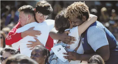  ?? AP PHOTO ?? COMING TOGETHER: Attendees comfort each other at a prayer vigil for the victims of the shooting at Marjory Stoneman Douglas High School in Parkland, Fla., held yesterday at Parkland Baptist Church.