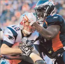  ?? Barry Gutierrez Associated Press ?? NEW ENGLAND PATRIOTS quarterbac­k Tom Brady, left, pushes up against Denver Broncos defensive end Robert Ayers.