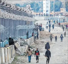  ?? EFE ?? Rafah. Desplazado­s caminan junto a la frontera palestino-egipcia.