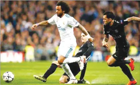  ??  ?? Real Madrid’s Marcelo (left) dashing away from two PSG defenders during their UEFA Champions League Round of 16 clash at the Estadio Santiago Bernabeu in Madrid, Spain…last night