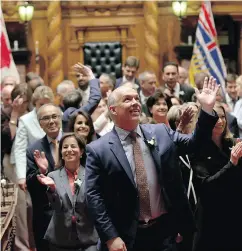  ?? CHAD HIPOLITO / THE CANADIAN PRESS ?? B.C. NDP leader John Horgan waves to supporters in the legislativ­e gallery following a swearing-in ceremony at Legislatur­e in Victoria, B.C. last Thursday.