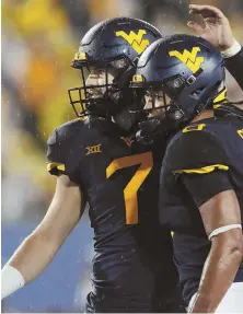  ?? AP PHOTOS ?? WASHED OUT: N.C. State quarterbac­k Ryan Finley (left, 15) and West Virginia counterpar­t Will Grier (right, 7) were slated to meet today, but their scheduled game in Raleigh, N.C., was canceled because of Hurricane Florence.