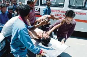  ??  ?? SRINAGAR: Kashmiri villagers bring a resident injured by Indian security personnel to the main hospital in Srinagar yesterday. —AFP