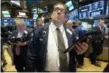  ?? RICHARD DREW — THE ASSOCIATED PRESS ?? Trader Robert Oswald, center, works on the floor of the New York Stock Exchange on Thursday.