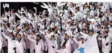  ?? FOTO: WARMUTH/DPA ?? Historisch­e Szene: Die gemischte Mannschaft aus Süd- und Nordkorea lief, in weiße Jacken, gemeinsam ein.