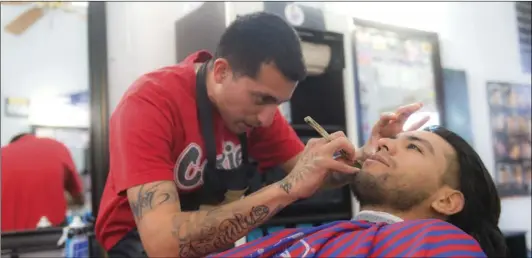  ??  ?? Barber Omar Guzman (left) lines up Brawley resident Jaime Nunez at the King Of Fadez Barbershop in Brawley on Saturday, during which the barbershop raised over $1,000 to help cover the funeral costs of a 24-year-old Brawley man recently killed in a...