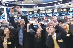  ?? — AP ?? NEW YORK: Executives and guests of Pampa Energia, an Argentine electric company, photograph their colleagues during the opening bell of the New York Stock Exchange yesterday.