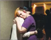  ??  ?? Missy Ezell, 26, left, hugs Lola McCall, 30, during a break in recording a tribute song for Ghost Ship fire victims.