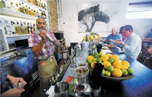  ?? PHOTOS BY LUIS SÁNCHEZ SATURNO/THE NEW MEXICAN ?? Bartender Pedro Arias-Gil of Santa Fe mixes a margarita at the bar Monday as Lloyd Abrams, back right, and Randall Onstead, front right, of Santa Fe eat their meals at the bar at Paloma on South Guadalupe Street.