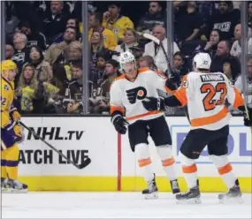  ?? JAE C. HONG — THE ASSOCIATED PRESS ?? Flyers center Sean Couturier, center, celebrates his goal with defenseman Brandon Manning against the Los Angeles Kings on Friday.