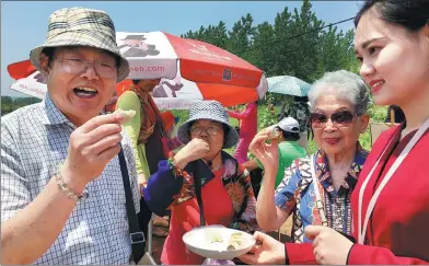  ?? PROVIDED TO CHINA DAILY ?? Homeowners in the new Tieshan Lake Forest Park retirement community, which welcomed its first 2,000 or so residents in March, try some rose cake.