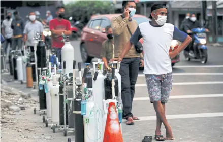 ?? REUTERS ?? People wearing protective masks queue to refill oxygen tanks on Monday as Indonesia experience­s an oxygen supply shortage amid a coronaviru­s surge, at a filling station in Jakarta.