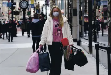  ?? MARK LENNIHAN — THE ASSOCIATED PRESS FILE ?? A womYn cYrries shopping bYgs in New York.