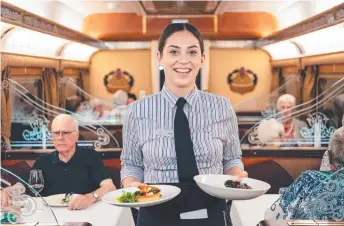  ?? ?? The Indian Pacific snakes through the landscape; you can relax and watch the world go by; the comfortabl­e Platinum service cabin.
Passengers enjoy dinner at Rawlinna in WA, above; staff are friendly and efficient; fine cuisine is offered in the dining carriages.