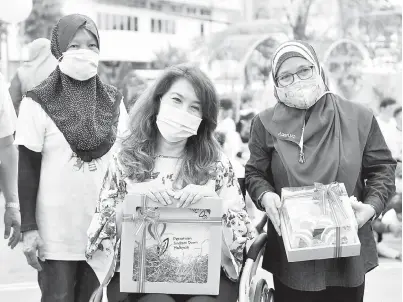  ??  ?? IKHLAS: Ras Adiba menerima cenderahat­i daripada Hanizan (kanan) pada Majlis Sambutan Hari Sindrom Down Sedunia 2021 di Persatuan Sindrom Down Malaysia, dekat ibu negara semalam. — Gambar Bernama