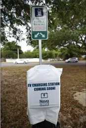  ?? JOHN RAOUX — THE ASSOCIATED PRESS ?? A parking area with charging stations for electric vehicles at a public park is seen Thursday in Orlando, Fla. As part of an infrastruc­ture proposal by the Biden administra­tion, $174 billion will be set aside to build 500,000 electric vehicle charging stations, electrify 20% of school buses and electrify the federal fleet, including U.S. Postal Service vehicles.