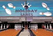 ??  ?? Two of Holiday Lanes Bowling Center real-wood lanes are prepared for bowling.
