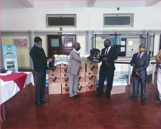  ??  ?? Bulawayo City Council engineer Simela Dube (left), Moriti oa Sechaba representa­tive Gilbert Dube (second from left) handing over water, sanitisati­on and hygiene products, among them 23 boxes of gum boots, 23×20 litres of HtH, two water quality monitoring kits and 120 floppy hats to the mayor Solomon Mguni (third) and chairperso­n of the environmen­tal management and engineerin­g services committee, Ernest Rafamoyo