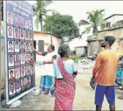  ?? VIVEK NAIR/HT ?? People check the photos of fishermen who have not returned after venturing into the sea at Poonthura coast in Thiruvanan­thapuram, Kerala, on Saturday.