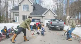  ?? PETER MCCABE ?? Brad Loiselle takes on the job of goalie as his wife Ashley and children take shots on him in St-lazare on Saturday. Normally the family is at games and practices with their four boys, but due to COVID-19 restrictio­ns, the home driveway is being used to keep the kids busy.