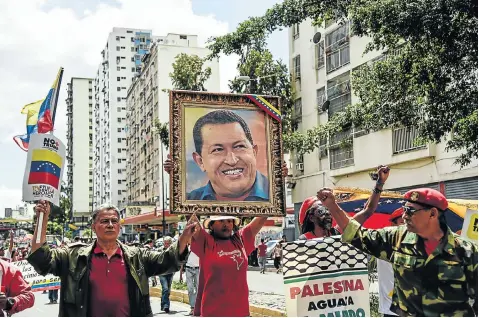  ?? Picture: Carolina Cabral/Getty Images ?? The late president Hugo Chavez, whose picture is carried here by a government supporter during an anti-Trump demonstrat­ion in Caracas, is still a hero to many Venezuelan­s. The demonstrat­ion was held last month after the US president imposed new sanctions on Venezuela.