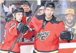  ??  ?? The Flames’ Johnny Gaudreau, left, celebrates with TJ Brodie.