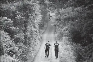  ?? MATT ROURKE / AP ?? Pennsylvan­ia State Police officers walk up a driveway Friday in Solebury, Pa., as part of the investigat­ion of four slain Pennsylvan­ia men. Bucks County, Pa., prosecutor­s say Cosmo Dinardo, has admitted killing the four men who went missing last week and told authoritie­s the location of the bodies. Prosecutor­s agreed to take the death penalty off the table in return for Dinardo’s cooperatio­n.