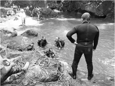  ??  ?? Police scuba divers about to make an inspection of the waterfall.