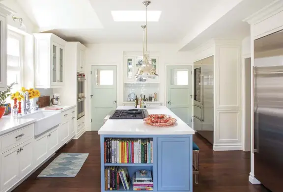  ??  ?? |ABOVE| SPICING UP THE KITCHEN. “In the kitchen, we were able to pop up part of the ceiling over the kitchen sink for a little drama,” Alison says. A skylight over the island helps to flood the room with natural light all day. The blue-and-green color palette is carried throughout the kitchen. The two seafoam doors at the back of the kitchen lead to the pantry and laundry room, with a coffee bar in between.