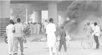  ??  ?? Rioters light fires on the streets of northern Nigeria’s ancient city of Kano in protest over the appointmen­t of Nigeria’s former Governor of the Central Bank Sanusi Lamido Sanusi as the new emir of Kano. Nigeria’s new Muslim monarch, the Emir of Kano,...