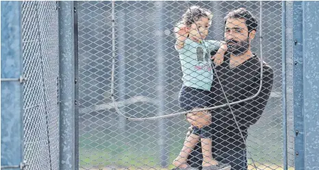  ?? FOTO: PATRICK PLEUL/DPA ?? Ein Vater aus dem Irak und seine Tochter in der Zentralen Erstaufnah­meeinricht­ung für Asylbewerb­er des Landes Brandenbur­g.