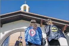  ??  ?? MOURNERS wear superhero attire in honor of the youngster. Authoritie­s believe he was tortured for days before he died last month.