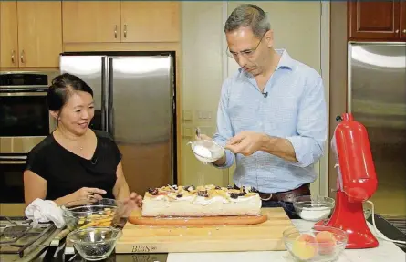  ?? MYUNG J. CHUN / LOS ANGELES TIMES PHOTOS BY ?? Yotam Ottolenghi, right, and Helen Goh assemble a fruit pavlova, one of the many dessert recipes from their new book, “Sweet.”