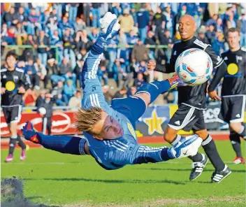  ?? FOTO: ROLF RUPPENTHAL ?? So schön kann man Schlussman­n Marc Birkenbach von Saar 05 Saarbrücke­n nur noch selten fliegen sehen: Er beendet seine Karriere und wird Torwart-Trainer. Unser Archivfoto zeigt eine der vielen Glanzparad­en in seiner langer Karriere. Es stammt vom Saarlandpo­kal-Halbfinale 2012 gegen den 1. FC Saarbrücke­n, das Saar 05 mit 0:3 verlor.