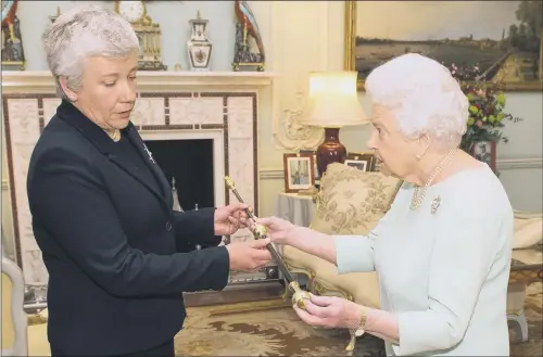  ??  ?? The Queen hands over the ceremonial staff of office to Sarah Clarke, who has been appointed the Lords’ first female Black Rod in 650 years.