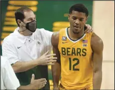  ?? Associated Press ?? ROUGH SEASON — Baylor head coach Scott Drew, left, talks with guard Jared Butler (12) as he leaves the game late in the second half against Stephen F. Austin in Waco, Texas, on Wednesday.