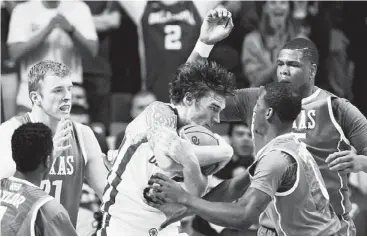  ?? Alonzo Adams / Associated Press ?? Oklahoma forward Ryan Spangler doesn’t let the fact that he’s surrounded by Texas Longhorns prevent him from winning a battle for a loose ball in the second half of the Sooners’ win Saturday in Norman, Okla.