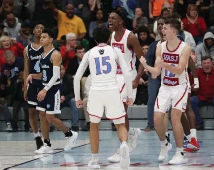  ?? TIM PHILLIS — FOR THE NEWS-HERALD ?? VASJ players celebrate their overtime win against Benedictin­e on Jan. 11.