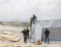  ?? (Flash90) ?? JEWISH MEN construct modular structures at the Homesh outpost in the West Bank last week.