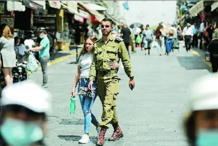  ?? EFE ?? Una pareja de jóvenes pasea ayer por las calles de Jerusalén sin mascarilla tras caer los contagios