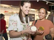  ??  ?? Jess Morrish (left) and Tara-Lea Saunders look over artisan candles at Hand Made Under the Stars.