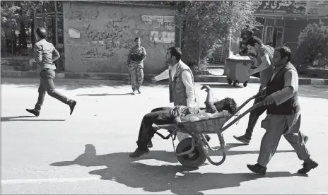  ?? RAHMAT GUL/ASSOCIATED PRESS ?? Afghan men carries a wounded man after the second blast Monday in Kabul, Afghanista­n. A coordinate­d double suicide bombing hit central Kabul on Monday morning.