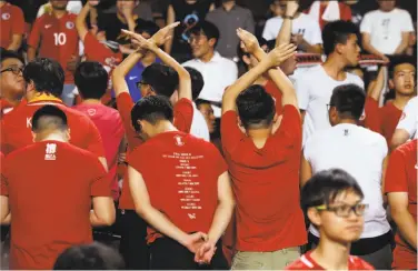  ?? Kin Cheung / Associated Press ?? Soccer fans turn their back during the Chinese national anthem at a recent match against Malaysia. The protesters believe Hong Kong’s autonomy and unique identity are being undermined by Beijing.