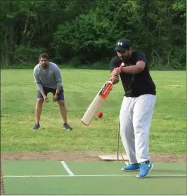  ?? Photo by Joseph B. Nadeau ?? Poorna Komatiredd­y bats while Drupad Anantala, left, plays keeper, as a group practices on Woonsocket’s new cricket pitch at Adrian Bissonnett­e Field.