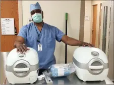  ?? SUBMITTED PHOTO ?? Dr. Miguel West, a transplant procuremen­t surgeon with Gift of Life Michigan, poses with a pair of kidney transport machines. The new technology provides a sealed steril environmen­t where a specially formulated solution is pumped through the kidney to minimize tissue damage.