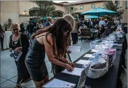  ?? Bobby Block/The Signal ?? Denise Hollert and Susan Lentini look at gift baskets being auctioned Saturday at Soup for the Soul, an event benefiting Bridge to Home.