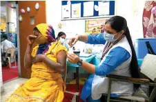  ?? — AFP ?? A health worker inoculates a woman with a dose of the Covaxin vaccine against the Covid-19 coronaviru­s at a health centre in New Delhi. photo