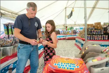  ?? NWA Democrat-Gazette/BEN GOFF • @NWABENGOFF ?? Savannah Sturdivant and father John Sturdivant of Centerton shop for fireworks Saturday at Fireworks City in Benton County near Centerton.