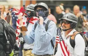  ?? Chip Somodevill­a, Getty Images ?? DC Metro Police form a protective phalanx around participan­ts in the Unite the Right rally as they march to White House on Sunday.